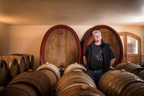 a man standing in front of two large barrels at Hotel Braun in Fahr