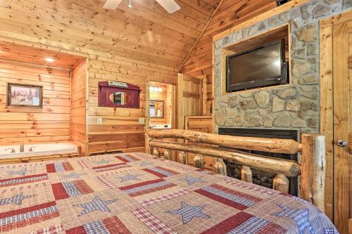 a bedroom with a bed and a television in a cabin at 3 Mi to Dollywood Hot Tub Hideaway in Smoky Mtns in Pigeon Forge