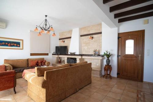 a living room with two couches and a fireplace at Great View villa in Sivota
