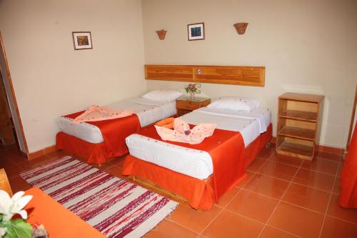 2 Betten in einem rot-weißen Zimmer in der Unterkunft Ali Baba Safaga Hotel in Hurghada
