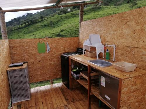 a kitchen with a counter and a sink in a house at Domo Glamping Kalpavriksha - Jostcolombia in La Vega