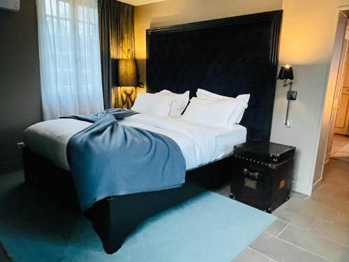 a bedroom with a large bed with a blue blanket on it at Moulin Royale in Saint-Etienne-Roilaye