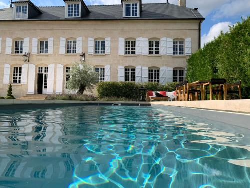une piscine en face d'un bâtiment dans l'établissement Moulin Royale, à Saint-Etienne-Roilaye