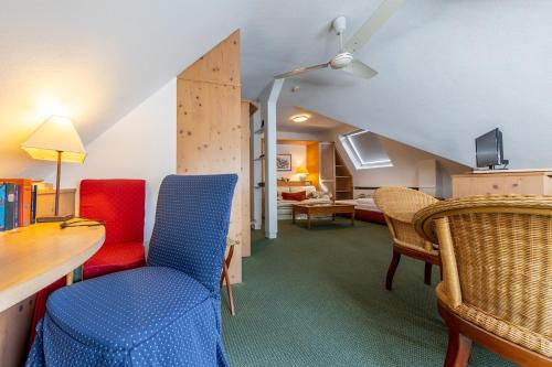 Habitación con sillas, escritorio y sala de estar. en Thermen Hotel & Restaurant Bad Soden en Bad Soden am Taunus