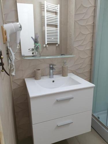 a bathroom with a white sink and a mirror at Caprice Deluxe Accomodation in Drobeta-Turnu Severin