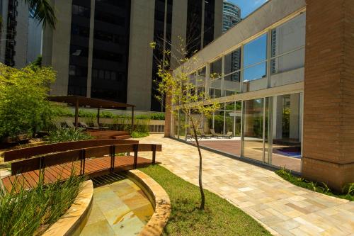 un banco de madera sentado frente a un edificio en Aconchegante Duplex no Brooklin III, en São Paulo