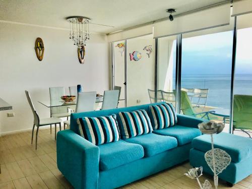 un salon avec un canapé bleu et une salle à manger dans l'établissement La Choza VIP Turquesa en La Serena, frente al mar, à Coquimbo