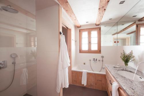 une salle de bain avec une baignoire, un lavabo et une douche dans l'établissement Chalet Bizet - A touch of Parisian design in the Alps, à Montriond