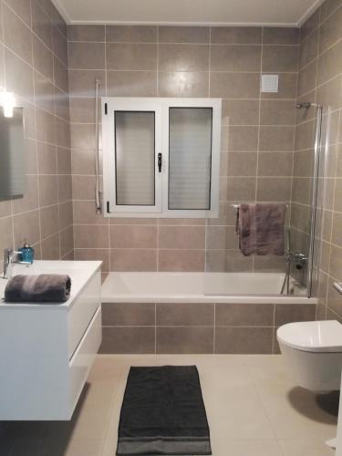 a bathroom with a tub and a toilet and a sink at Pearl of Nazaré in Nazaré