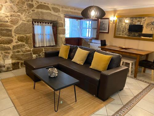 sala de estar con sofá de cuero y mesa en Casa Rualeira, en Combarro