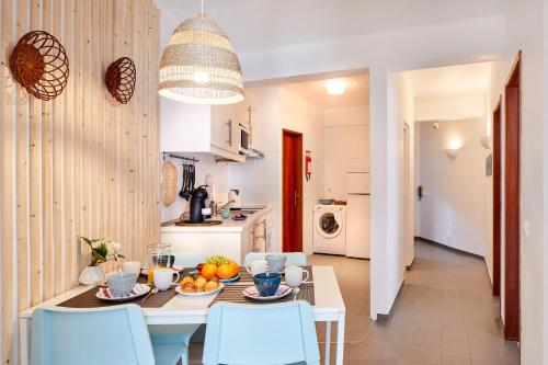 a kitchen and dining room with a table and chairs at Casas Barulho Apartment Old Town in Albufeira