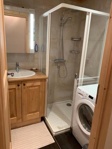 ein Badezimmer mit Dusche und Waschmaschine in der Unterkunft Le Rocher Blanc A in Courchevel