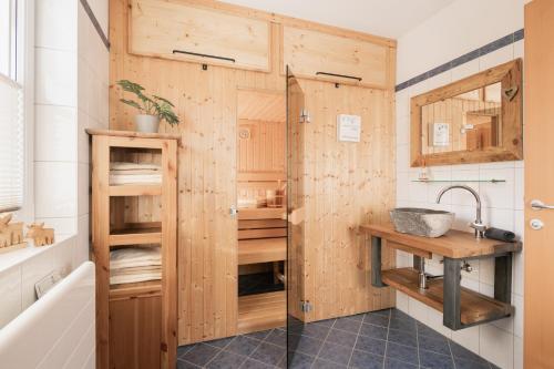 a bathroom with a shower with wooden walls at Pistenblick Chalet in Sankt Margarethen im Lungau