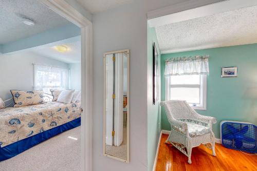 a bedroom with a bed and a chair and a window at Hampton Beach Hangout & Nancy's Villa in Hampton