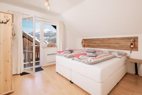 a bedroom with a bed and a large window at Pistenblick Chalet in Sankt Margarethen im Lungau