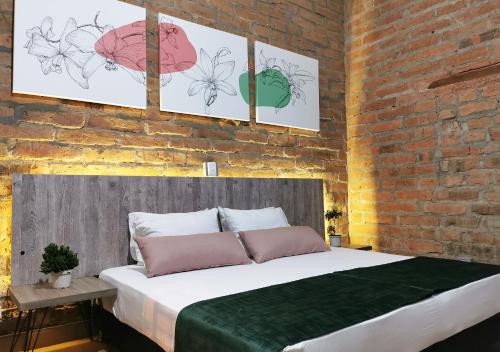 a bedroom with a large bed in a brick wall at Botánica Casa Hotel in Medellín