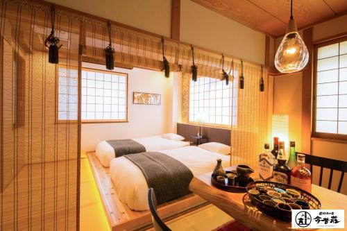 um quarto com 2 camas e uma casa de banho com janelas em Dotonbori no Yado Konjakuso - Vacation STAY 24305v em Osaka