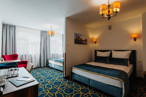 a hotel room with a bed and a living room at Hotel Jan in Kraków