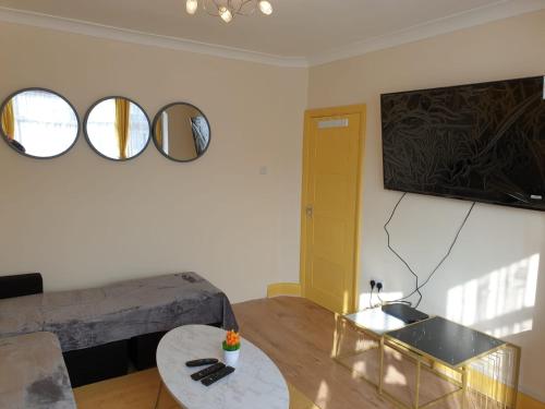 a living room with a couch and two mirrors on the wall at Large 4bed house up to 6 beds parking Slough Train Station in Slough