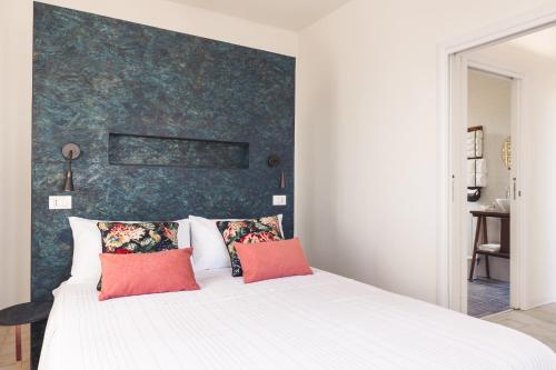Casa Villea في ترابيا: غرفة نوم مع سرير أبيض كبير مع وسائد حمراء