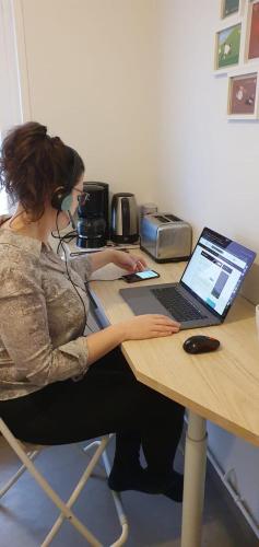 a woman sitting at a table with a laptop at Waikiki in Biarritz