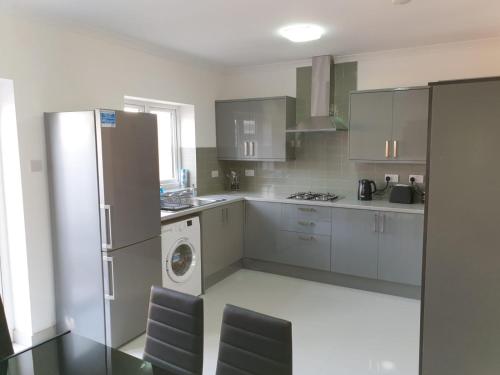 een keuken met een koelkast en een wasmachine bij Large 4bed house up to 7beds parking Slough Train Station in Slough