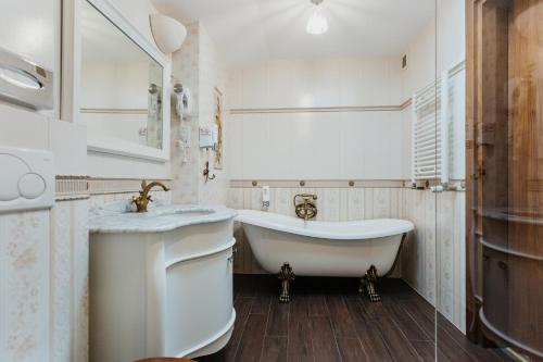 a white bathroom with a tub and a sink at Hotel Jan in Kraków