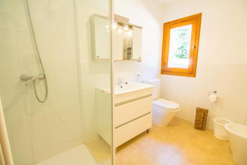 a bathroom with a shower and a sink and a toilet at Villa Señorial primera linea de playa in Pollença