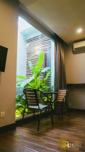 a table and chairs in a room with a window at Hotel Five.S in Kampot