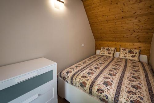 a small bedroom with a bed and a dresser at Ciprus Lak in Szarvas