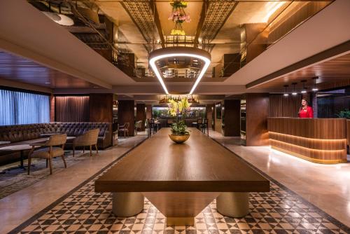 a restaurant with a large wooden table in the middle of a room at Hotel Estelar La Fontana in Bogotá