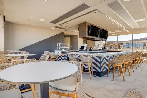 a restaurant with tables and chairs and a bar at Omni Oklahoma City Hotel in Oklahoma City