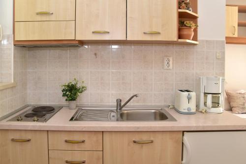 a kitchen counter with a sink and a coffee maker at Old town studio apartments in Makarska
