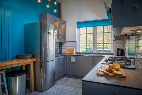 a kitchen with a refrigerator and some bread on a cutting board at Highland Annexe, Munlochy, The Black Isle in Munlochy