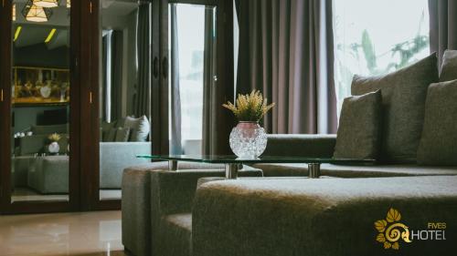 a living room with a vase on a coffee table at Hotel Five.S in Kampot