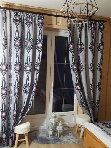 a bedroom with black and white curtains and a window at VILLA JAGODOVO Biały Dunajec in Biały Dunajec