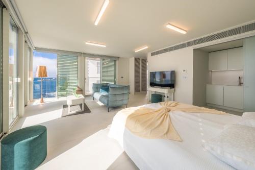 a bedroom with a large bed and a living room at Barreirinha Suite Top Floor by Holiday Rental Madeira in Funchal