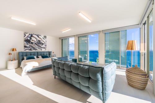 a bedroom with a bed and a large window at Barreirinha Suite Top Floor by Holiday Rental Madeira in Funchal
