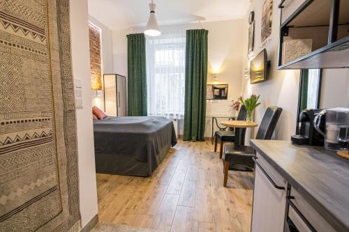 a hotel room with a bed and a kitchen at Green - Apartamenty Kleparskie in Kraków