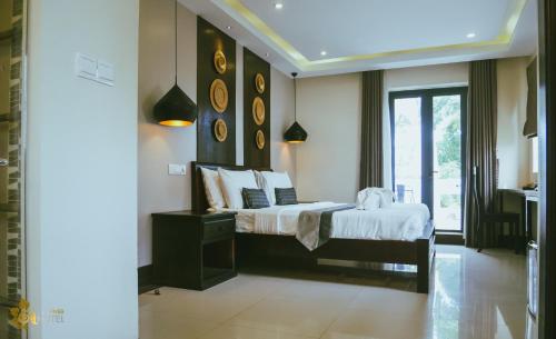 a bedroom with two beds and a large window at Hotel Five.S in Kampot