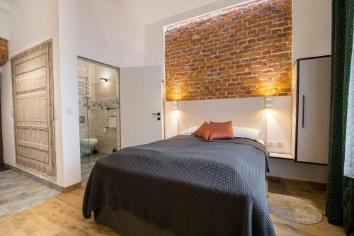 a bedroom with a bed and a brick wall at Green - Apartamenty Kleparskie in Kraków