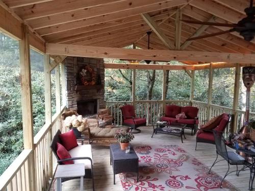 eine abgeschirmte Veranda mit Stühlen und einem Kamin in der Unterkunft Chic Cottage 1.7 miles to Downtown Highlands in Highlands