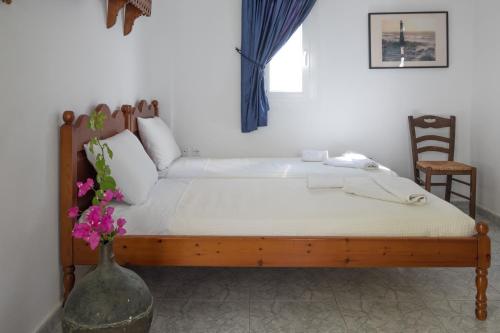 a bed in a room with a vase with flowers at Maistrali in Astypalaia Town