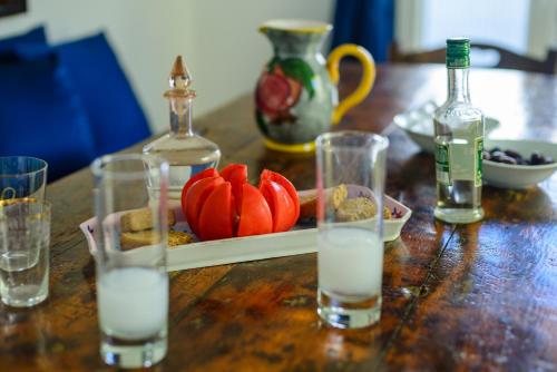 a wooden table with glasses of water and a bottle at Maistrali in Astypalaia Town