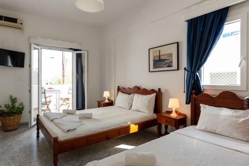 a bedroom with two beds and a balcony at Maistrali in Astypalaia Town