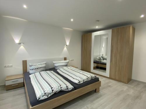 1 dormitorio con 1 cama grande y espejo grande en Ferienwohnung H&M Immobilien Hettstedt, en Hettstedt