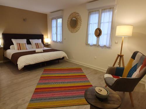 a bedroom with a bed and a chair and a rug at LA MARINA-Center-Parking-StationtoParis in Les Mureaux