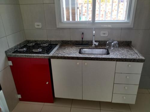 a kitchen with a sink and a stove at Lindo sobrado a 100 m praia do Aruan. in Caraguatatuba