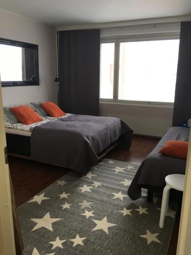 1 Schlafzimmer mit 2 Betten und einem Teppich in der Unterkunft StarHomes City Apartment 4 in Kemi