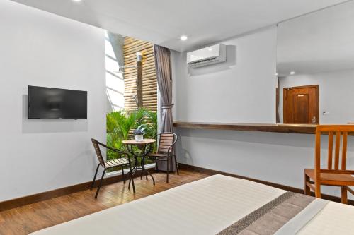 a hotel room with a bed and a table and chairs at Hotel Five.S in Kampot